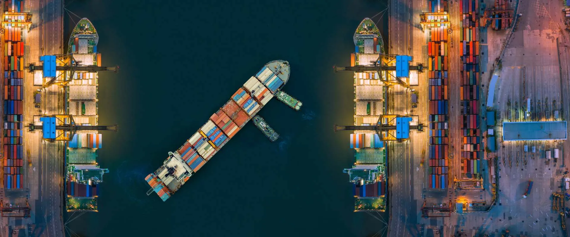 Aerial view of a container port at night with cargo ships at the docks