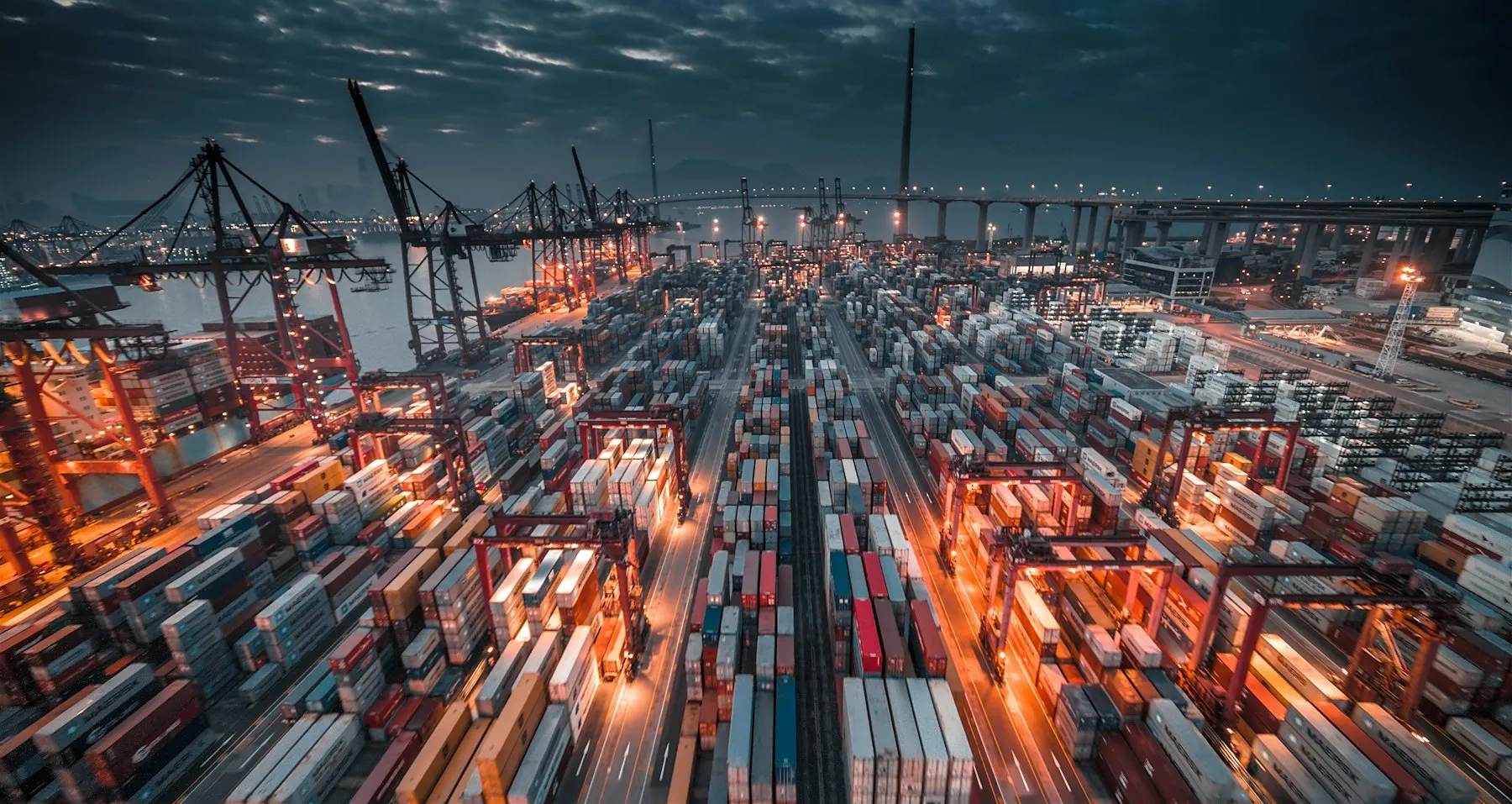 Container port at night with cranes loading cargo ships